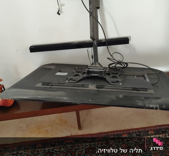 מסך טלוויזיה מנותק עם זרוע תלייה על הקיר